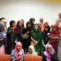 Color image of participants in a leadership development program gather around Malala Yousafzai (at center, in green) at the Confederation of Somali Community in Minnesota in August 2016.