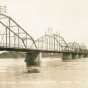 Black and white postcard image of the Anoka–Champlin Mississippi River Bridge, originally built in 1884, ca. 1920. 