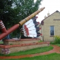 Color image of the world’s largest peace pipe, installed next to the Rock Island Depot in Pipestone. Photographed by Flickr user Josh Mattson, August 15, 2009.