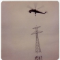 A crane helicopter lining up a power-line tower’s top portion with its base during construction of a high-voltage power line through Grant County, Minnesota, 1976-1978.