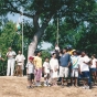 Color image of picnic attendees in St. Paul raise the national flag of India at an event held to celebrate India’s independence from Great Britain. Photographed by Anoop Mathur in August 2003.