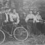 Henrietta Paist and others posed outdoors with a bicycle