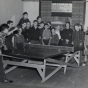 Black and white photograph of two boys playing ping pong at the Jewish Educational Center Annex while a group of children looks on, 1940.