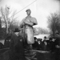 Black and white photograph of Josias King standing in front of a bronze statue patterned after his likeness, 1903. 