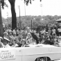 Black and white photograph of Eugene McCarthy in a parade, with daughters Ellen, Mary, and Margaret McCarthy, c.1964. 