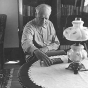 Black and white photograph of Charles Lindbergh in the living room of his restored boyhood home, 1971.