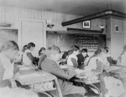 Black and white photograph of “intermediate” students inside a classroom at an Native American boarding school in Beaulieu, c.1900.