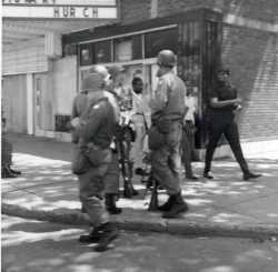 Black and white photograph of National Guardsmen patrolling Plymouth Avenue in North Minneapolis, July 1967.