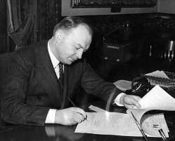 Black and white photograph of Harold Stassen signing a bill into law, 1941.