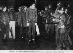 Members of the National Guard confront striking meatpacking plant workers in Albert Lea. Printed in the Minneapolis Morning Tribune, December 12, 1959. Original caption: “National Guardsmen dispersed crowds at Wilson Gate early Friday morning.” Photograph by Charles Brill.