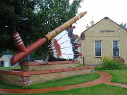Color image of the world’s largest peace pipe, installed next to the Rock Island Depot in Pipestone. Photographed by Flickr user Josh Mattson, August 15, 2009.