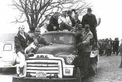 Black and white photograph of NFO farmers and creamery employees ride a bulk truck out to milk dumping site on the Martin Lampi farm near Annandale on March 7, 1963.
