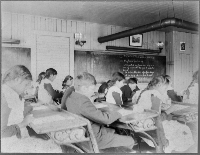 Black and white photograph of “intermediate” students inside a classroom at an Native American boarding school in Beaulieu, c.1900.