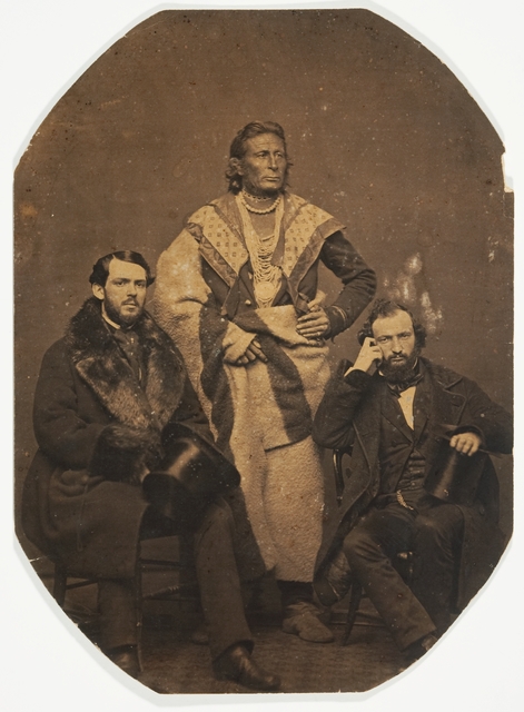 Black and white photo print of the Ho-Chunk (Winnebago) leader Baptiste Lasallier (center) with Indian Agent Charles H. Mix (right) and an Indian supply merchant from New York (left), 1857.