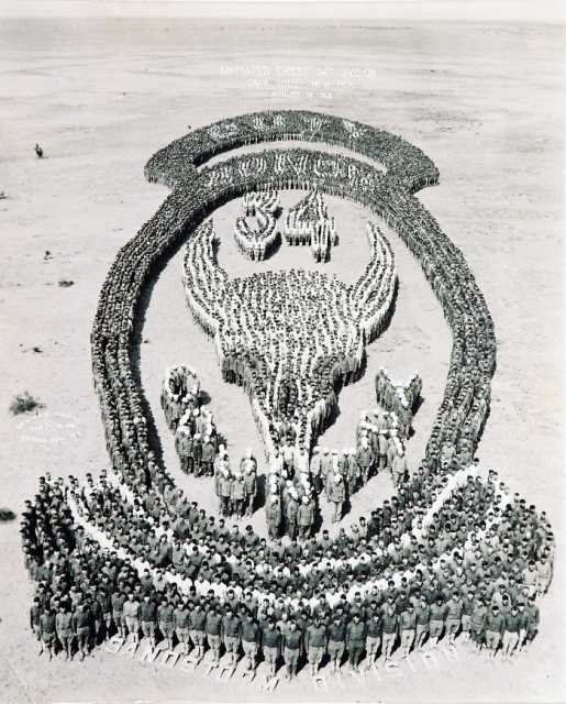 Black and white photograph of Thirty-fourth soldiers at Camp Cody, New Mexico, form an “animated” image of their shoulder insignia, just prior to their departure from camp, August 18, 1918.