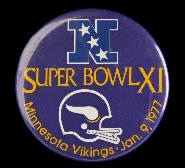 Color image of a plastic pin-back button commemorating the participation of the Minnesota Vikings in Super Bowl XI, played against the Oakland Raiders in Pasadena, California, 1977. The Raiders defeated the Vikings 32–14.