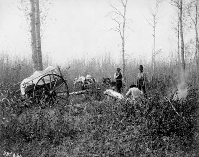 Black and white photograph of men and Red River carts near Dennis Lake, Manitoba, 1897.