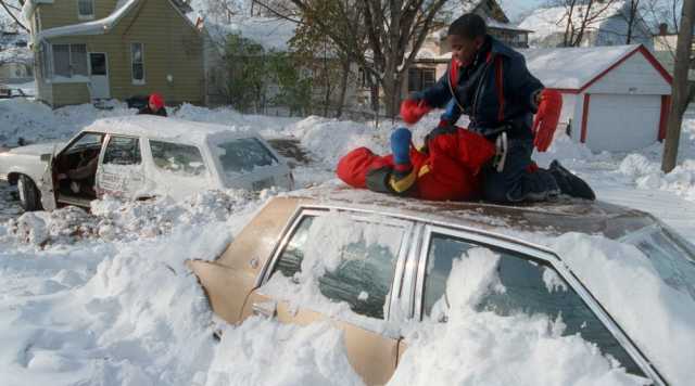 Color image of children playing on top of a car after the Halloween Blizzard, 1991. Photograph by Marlin Levison, Minneapolis Star Tribune. 