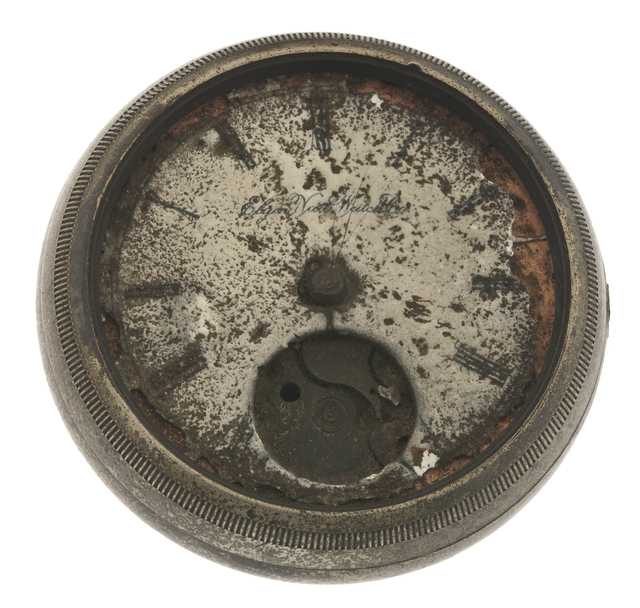 A pocket watch taken from the hand of a victim of the Great Hinckley Fire of 1894. The watch has a silver alloy case and a white porcelain face. Manufactured in 1884 by the Elgin National Watch Company of Elgin, Illinois.