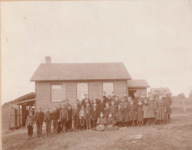 Photograph of Zoar public school (District #20) c.1895. Teacher Vena Abbott stands with her students outside the school building. Photograph Collection, Carver County Historical Society, Waconia.