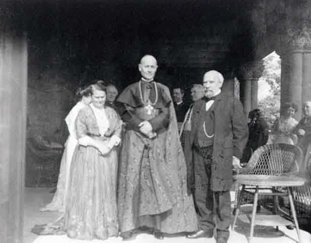 Black and white photograph of Mary T. and James J. Hill with Cardinal Vannutelli, a Papal delegate, on the Hill House veranda, 1910.