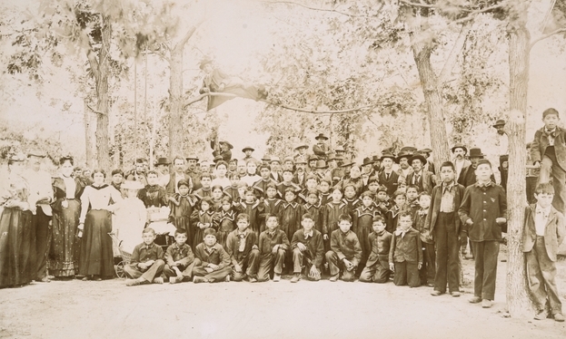 Black and white photograph of students and staff of a Native American boarding school, c.1900.