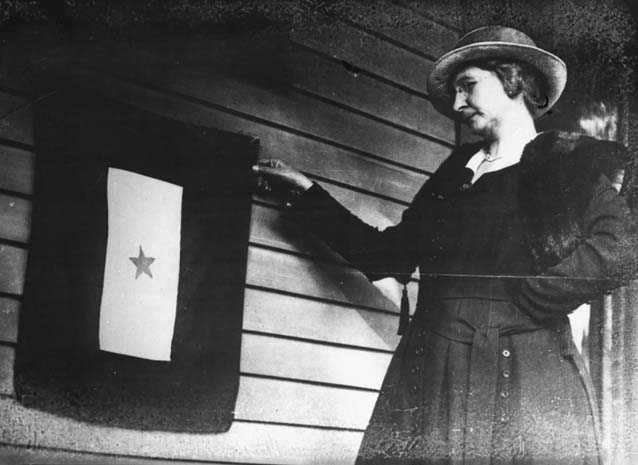 Black and white photograph of Mrs. J. P. Mohan, Gold Star mother, with flag, St. Paul, 1918.