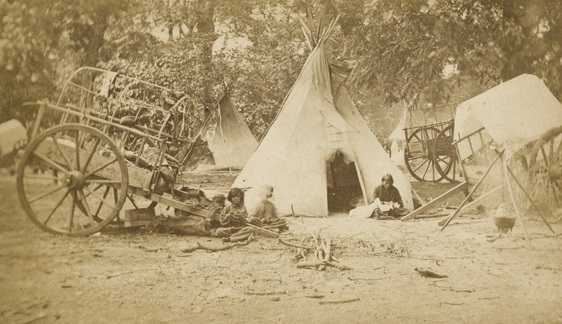 Black and white photograph of a Red River cart at a Dakota family’s camp, ca. 1870. 