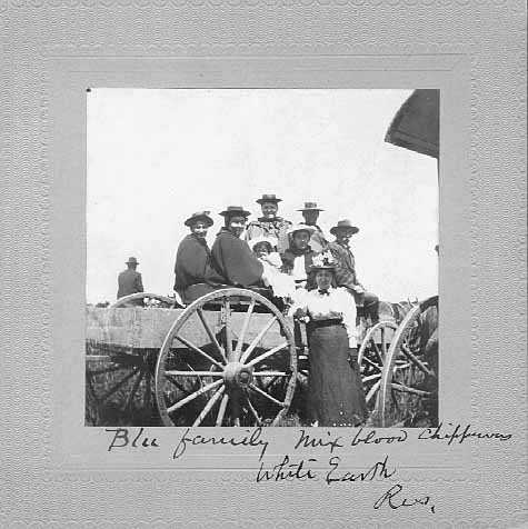 Black and white photograph of an eight-person mixed-blood Ojibwe family, including a baby, on the White Earth Reservation, ca. 1897.