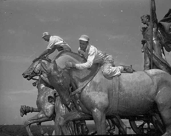 Black and white photograph of workers removing the gold leaf on the Quadriga at the Minnesota State Capitol, St. Paul, 1949.