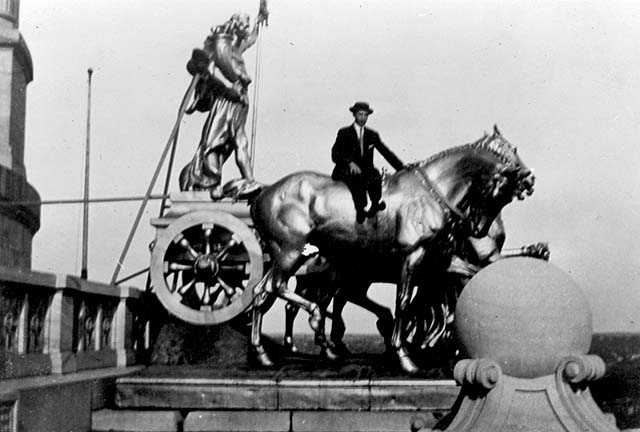 Black and white photograph of men posed at the quadriga, c.1913. Photographed by Earl Conrad.