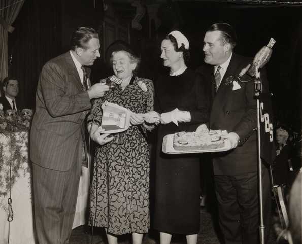 Black and white photograph from the Grand National Bake-Off at the Waldorf Astoria, New York, 1950. Left to right: Art Linkletter, contestant, Duchess of Windsor (the former Wallis Simpson), Philip Pillsbury.