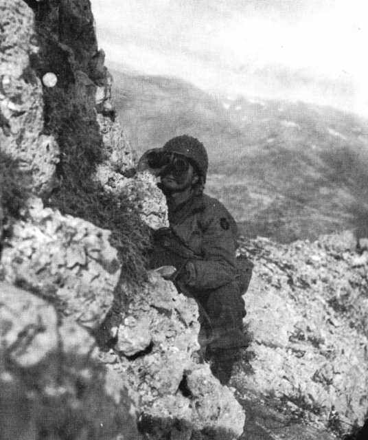 Black and white photograph of a Thirty-fourth Infantry Division officer scanning German movements on the approach to Casino, 1944.