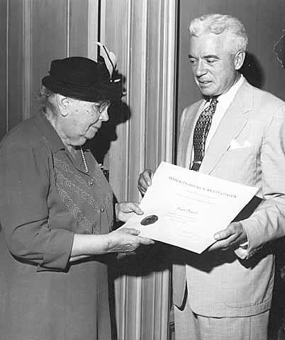 Black and white photograph of Frances Densmore being presented with citation by Harold Dean Carter. 
