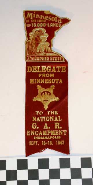 Ribbon worn by Albert Woolson at the national Grand Army of the Republic (GAR) encampment in Indianapolis held between September 13 and 18, 1942. Attached to the maroon ribbon is a matching Minnesota pin with a gopher that reads, "Minnesota in the Land of 10,000 lakes" and "The Gopher State." The ribbon was donated by his daughter, Frances Campbell, to the St. Louis County Historical Society in Duluth.