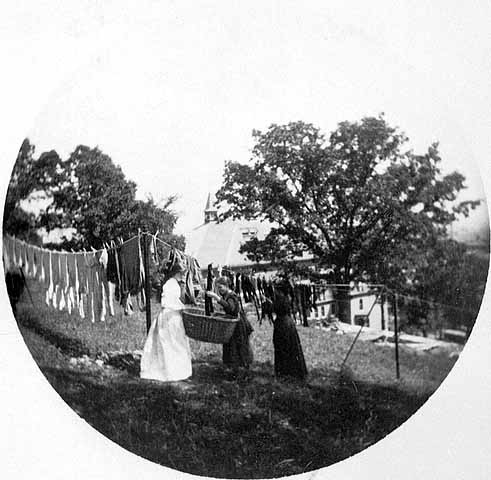 Black and white photograph entitled "Hanging up the clothes" at the James J. Hill House, 240 Summit, St. Paul, c.1900.