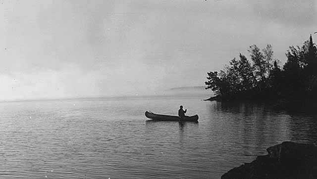 Black and white image of an individual canoeing on Lake Vermilion, 1935. 