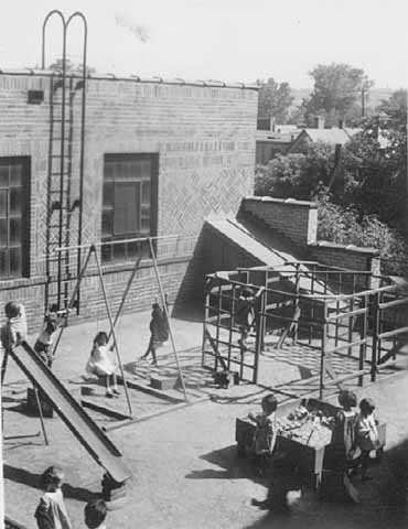 Black and white photograph of children playing on the playground of St. Paul’s Neighborhood House in 1937.