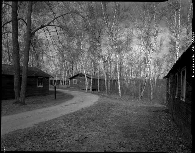 Northwest section of CCC Camp Rabideau F-50, looking southwest, with (left to right) barracks, education building, barracks, and recreation hall. Photo by Jerry Mathiason, 1994. From box 1 (144.G.8.4F) of Historic American Buildings Survey records related to Minnesota structures, 1882-2001, 1883. Manuscripts Collection, Minnesota Historical Society, St. Paul.