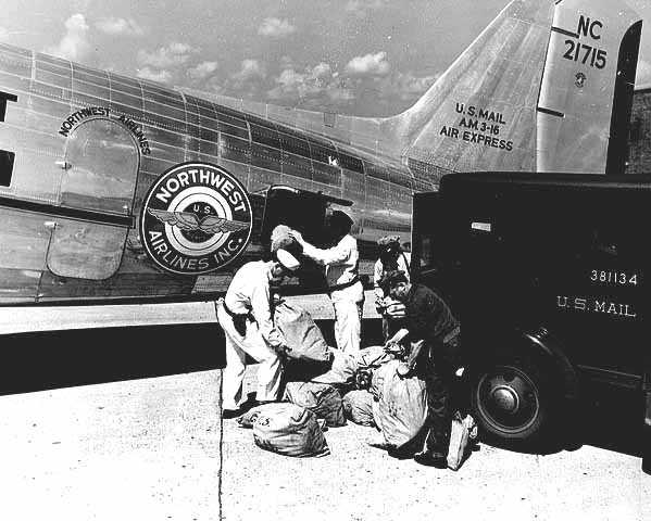 Black and white photograph of an air mail being loaded onto a Northwest Airlines plane, c.1940.