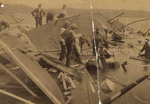 Black and white photograph of rescue workers searching for bodies in the wreckage of the Sea Wing, 1890. 