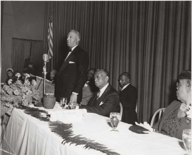 Black and white photograph of a Frank Boyd testimonial dinner, with A. Philip Randolph standing, 1951. 