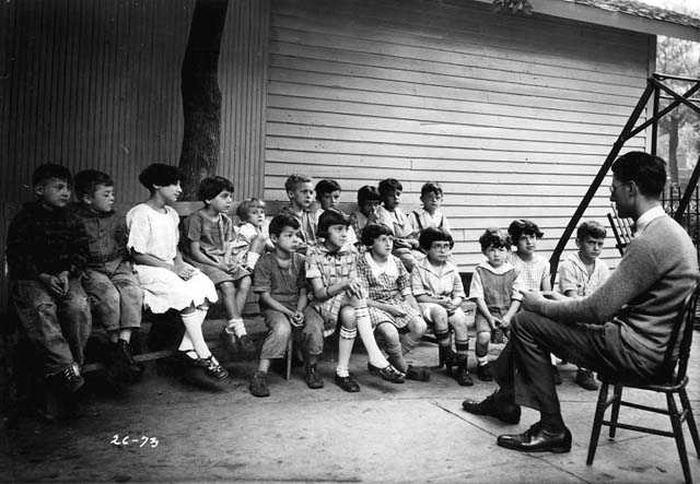 Black and white photograph of a man telling a story to residents of the Jewish Sheltering Home for Children in Minneapolis, c.1925.