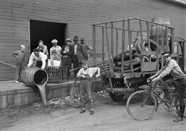 Black and white photograph of a group of people dismantling a still at Pillsbury and Charles Streets in St. Paul, c.1925.