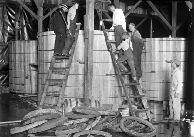 Black and white photograph of a group of people dismantling a still at Pillsbury and Charles Streets in St. Paul, c.1925.