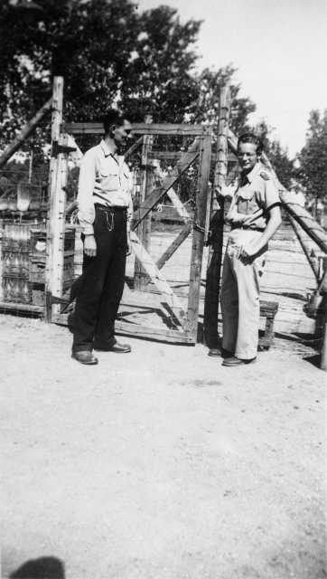Black and white photograph of Harvey Fleshner with a Peterson farm employee outside the gates of the German prisoner of war camp, ca. 1943–1945.  Used with the permission of the Historical and Cultural Society of Clay County. 