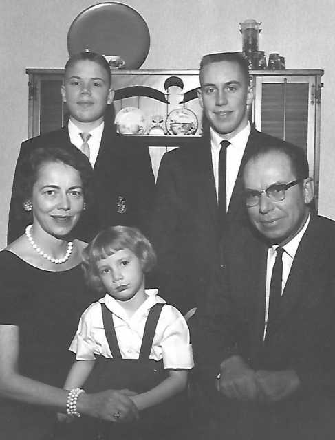 Black and white photograph of Ernotte and Ardis Hiller (seated), holding Mary Hiller; in the back are Chuck Hiller (right) and Jeff Hiller (left), 1961.