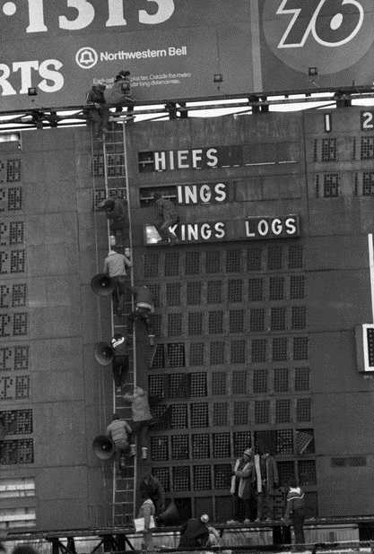 Black and white photograph of Viking fans strip the scoreboard after the Vikings lose to Kansas City in the last game played at Met Stadium, 1981. Photograph: John Doman, St. Paul Dispatch & Pioneer Press.