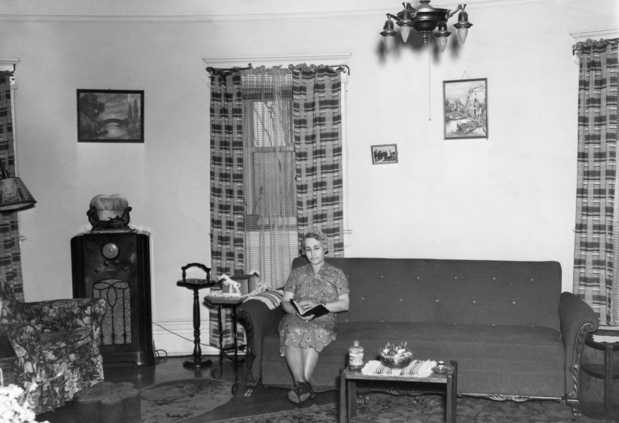 Black and white photograph of Mrs. Thomas Marcum, wife of the post's civilian electrical engineer, seated in her living room in the Round Tower, 1937.