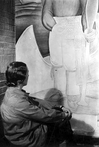 Black and white photograph of a mural in Minneapolis Armory by Elsa Jemne (seated before mural), c.1940. 